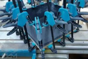 Процесс склейки деталей мойки из черного акрилового камня с белыми вкраплениями для кухонной столешницы, в цеху.