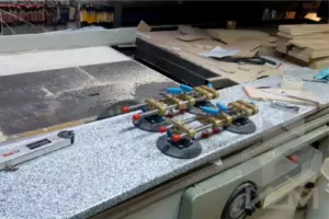 Процесс склейки подоконника из серого гранита вакуумными струбцинами для получения гладкой поверхности.