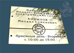 Латунная дверная табличка с выгравированным именем и должностью руководителя.